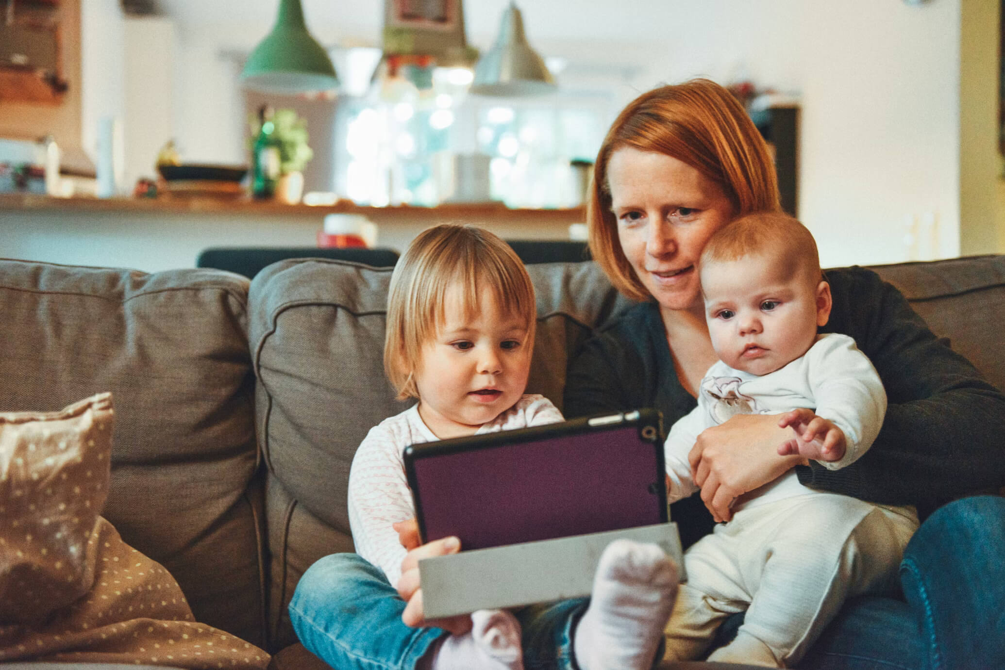 Image shows a foster carer with foster children in a home setting