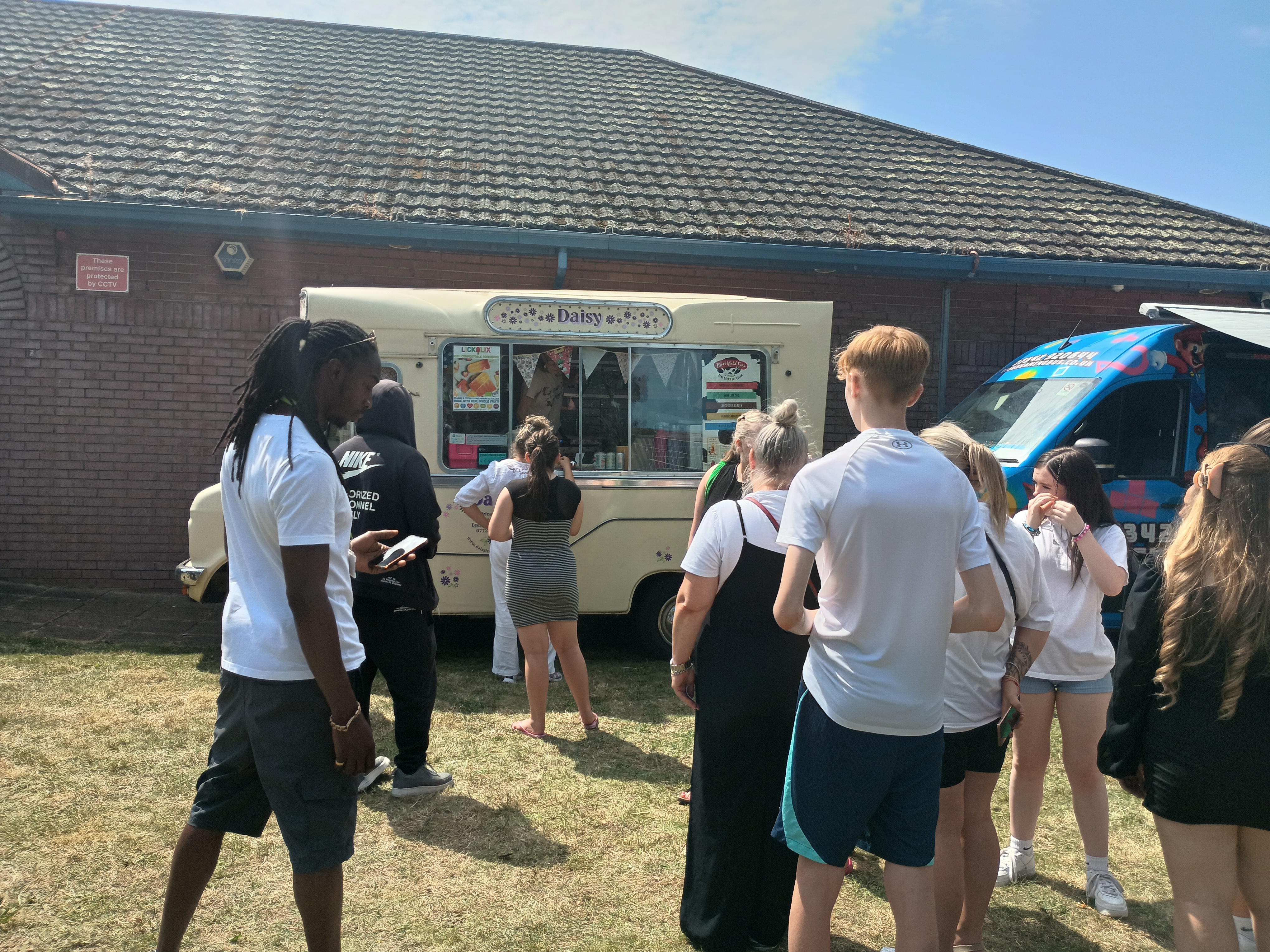 Picture at the Summer Fun day of young people waiting by an ice cream van