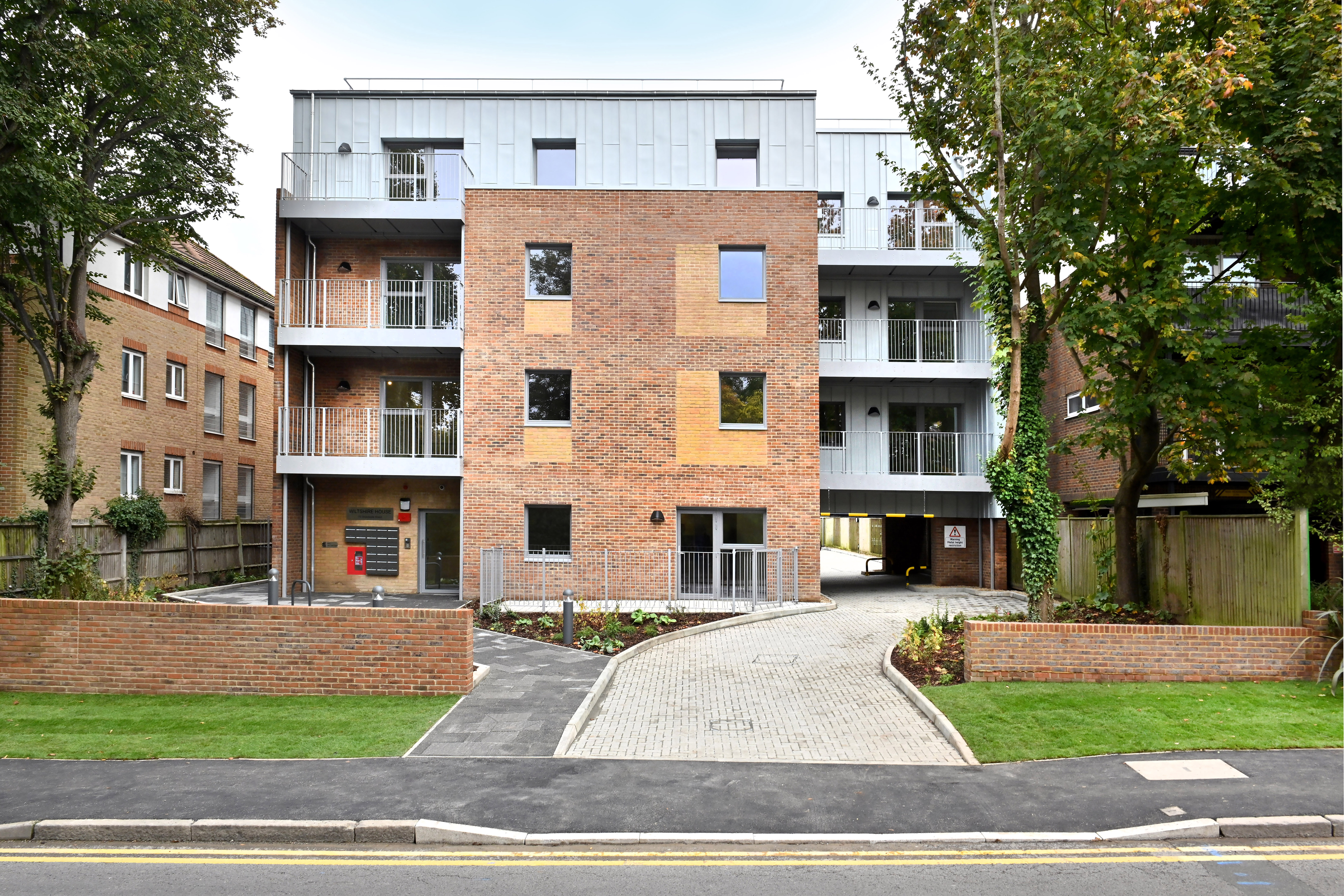 Front view of the new flats at Woodcote Road, showing the driveway and undercroft to the parking at the rear of the block.