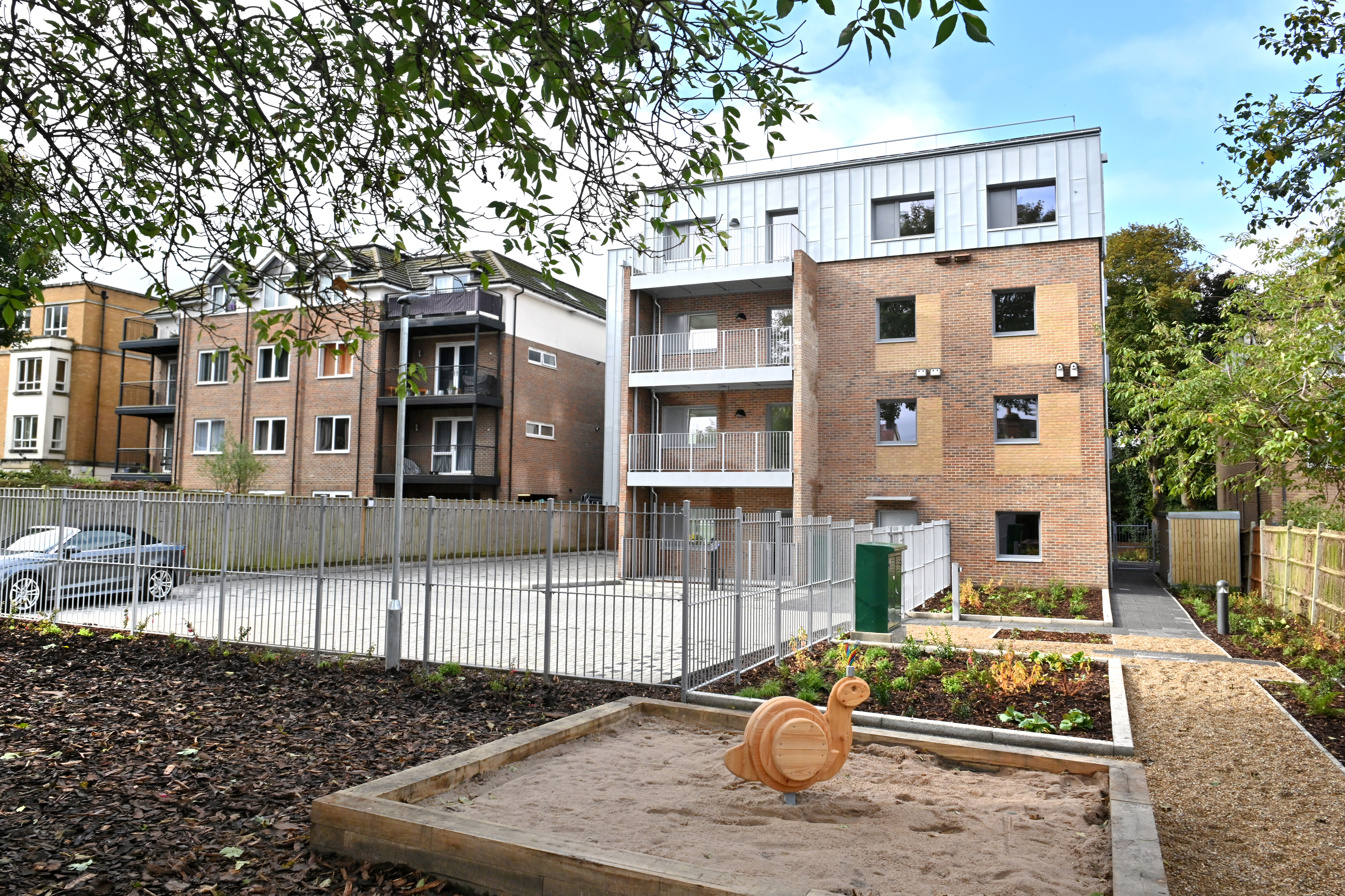 Rear view of the newly built modern flats in Woodcote Road, showing the parking and children's play area